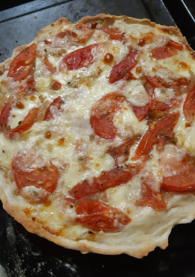 Una foto de Tarta de cebolla, tomate, queso y salsa blanca