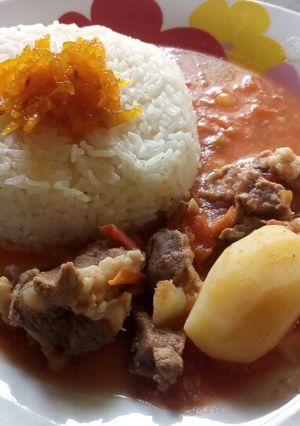 A picture of Rice and mutton soup curry with mango pickle.