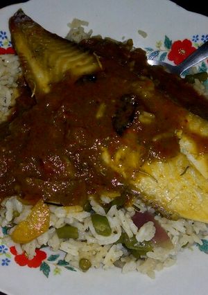 A picture of Vegetable rice with fish fillet topped with tomato sauce.