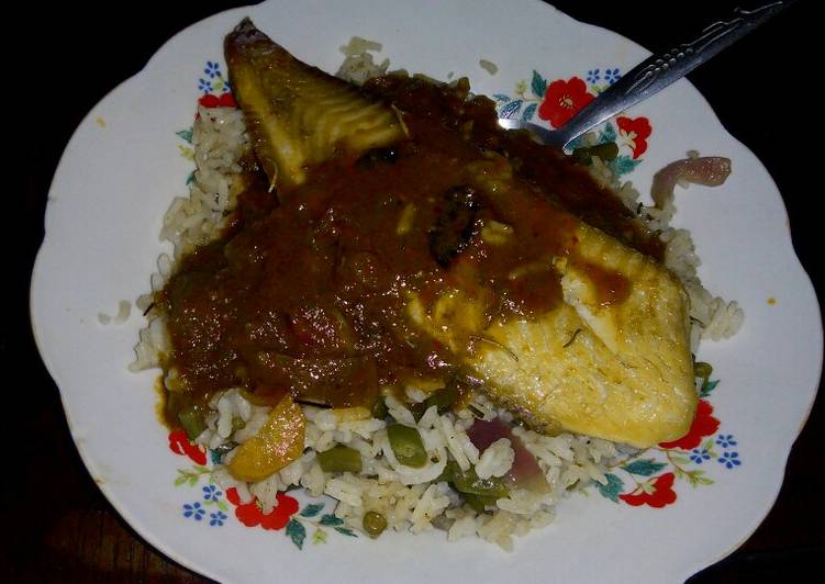 Vegetable rice with fish fillet topped with tomato sauce