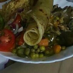 A picture of Rice and green peas and beef stew with kachumbari.