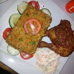 A picture of Jollof rice,coleslaw and grilled chicken.