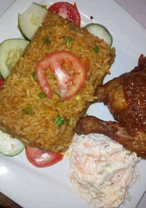 A picture of Jollof rice,coleslaw and grilled chicken.