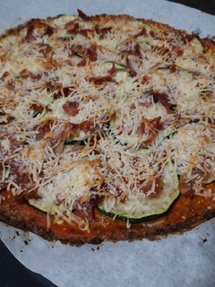 Una foto de Pizza con base de coliflor, de calabacín y jamón
