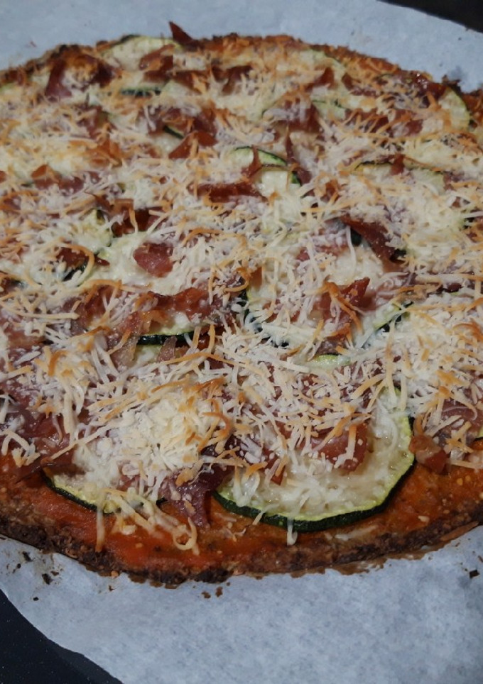 Una foto de Pizza con base de coliflor, de calabacín y jamón