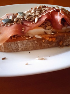 Una foto de Tostada con queso fresco, semillas y jamón