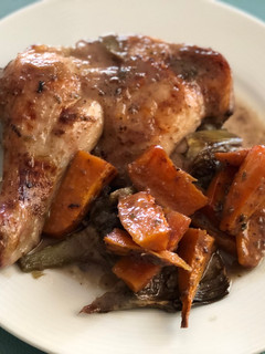 Una foto de Pollo al horno con alcachofas, boniato y salsa de uva