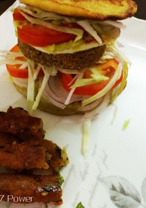 A picture of Semolina Avocado cake  veg burger with dal tikki  and stick.