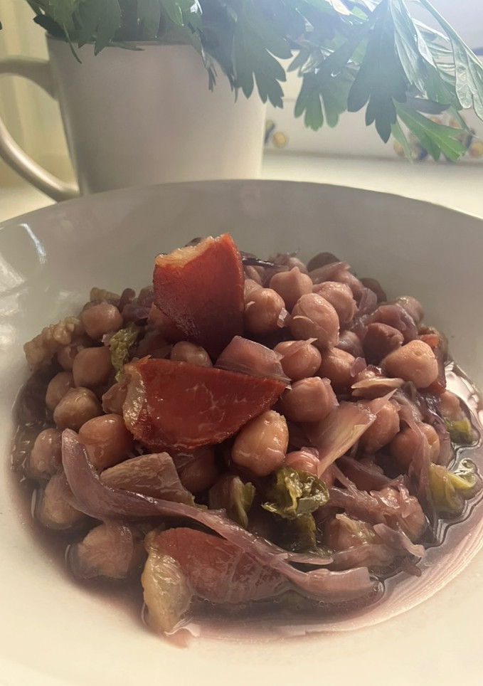 Una foto de Potaje de col lombarda y col china, con garbanzos y panceta ibérica