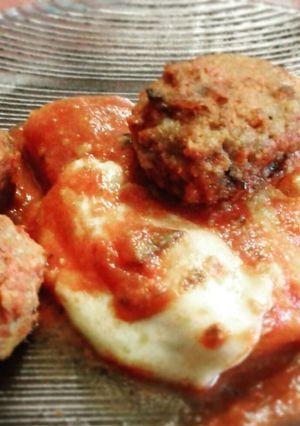 Una foto de Polenta con queso salsa y albóndigas