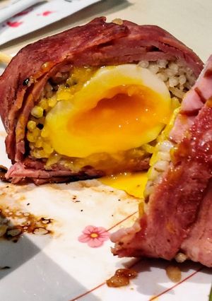 A picture of Bacon Wrapped Rice Ball with Soft Boiled Egg.