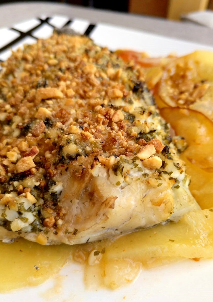 Una foto de Corvina al horno con costra de frutos secos