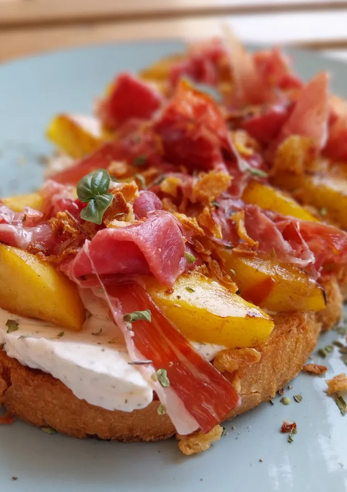 Una foto de Torrada de queso crema, nectarinas y jamón