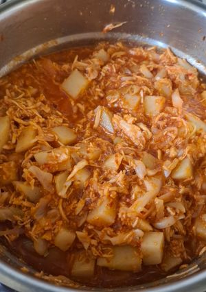 Una foto de Pollo deshebrado con papas en salsa roja