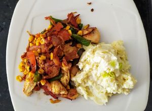 Una foto de Pollo salteado con vegetales estilo tailandés y puré de papas