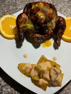 Una foto de Codorniz en salsa de naranja y papas bravas