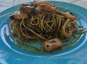 Una foto de pasta con calamares en su tinta