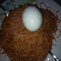 A picture of Jollof spaghetti with egg.