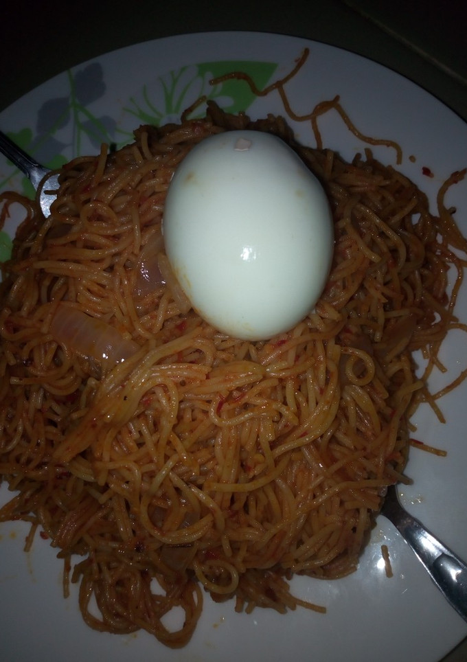 A picture of Jollof spaghetti with egg.