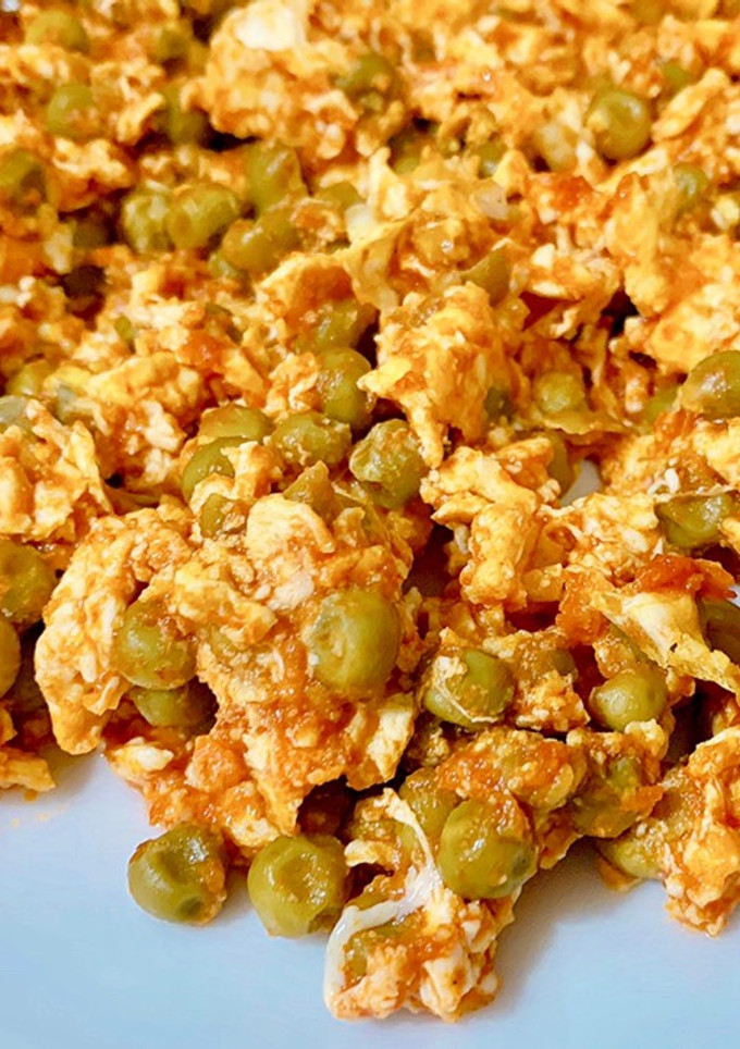 Una foto de Huevo con tomate y guisantes