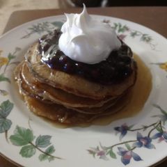 A picture of Cinnamon Clove Pancakes with Blueberry Sauce and Whipped Cream.