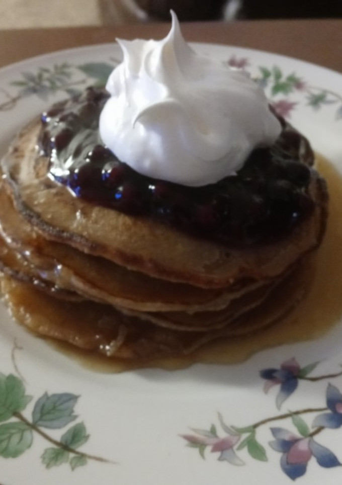 A picture of Cinnamon Clove Pancakes with Blueberry Sauce and Whipped Cream.