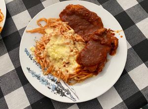 Una foto de Chuleta de Cerdo con Salsa de Guajillo y Spaghetti Rojo con Queso Mozzarella