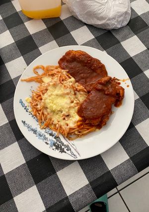 Una foto de Chuleta de Cerdo con Salsa de Guajillo y Spaghetti Rojo con Queso Mozzarella