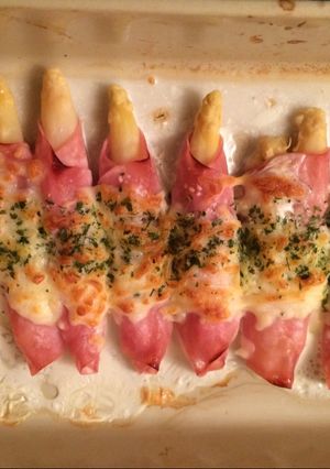 Una foto de Espárragos envueltos con jamón y queso gratinado