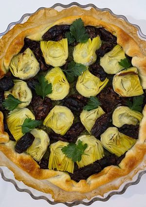 Une photo de La tarte salée au pesto, tomates séchées et cœurs d’artichauts. 🍅
