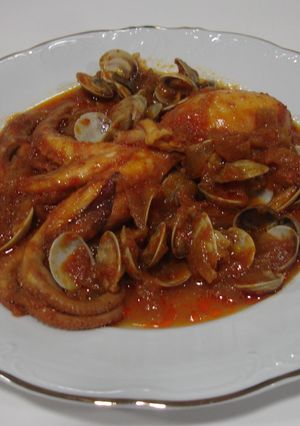 Una foto de Pulpo con salsa de tomate y almejas