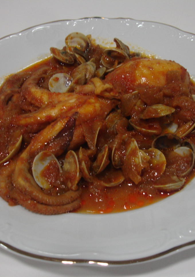 Una foto de Pulpo con salsa de tomate y almejas