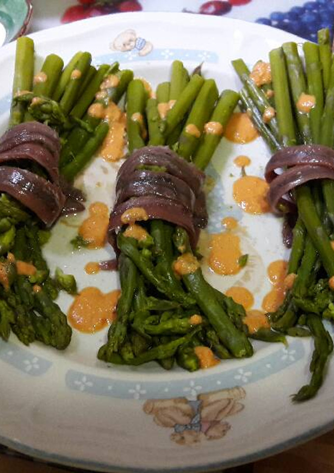 Una foto de Espárragos con anchoas y salsa de pimientos