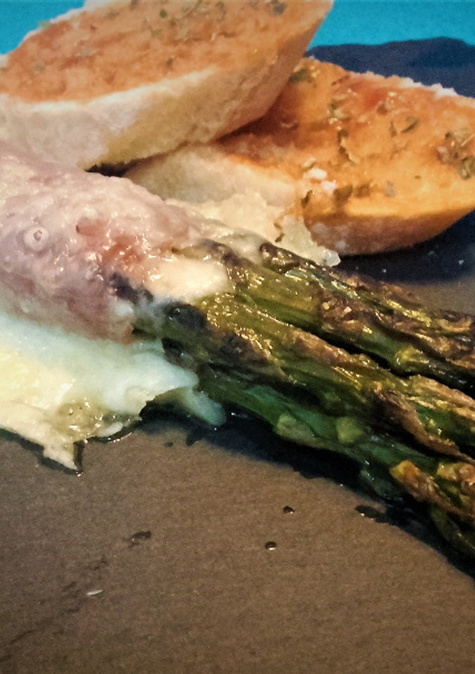 Una foto de Espárragos trigueros con jamón y queso