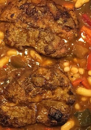 Une photo de Côtes de porc aux courgettes poivrons tomates et haricots blancs
