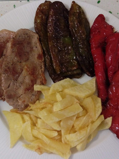 Una foto de Chuletas de cabeza de cerdo con patatas y pimientos fritos