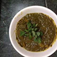 A picture of Aloo with green palak gravy.