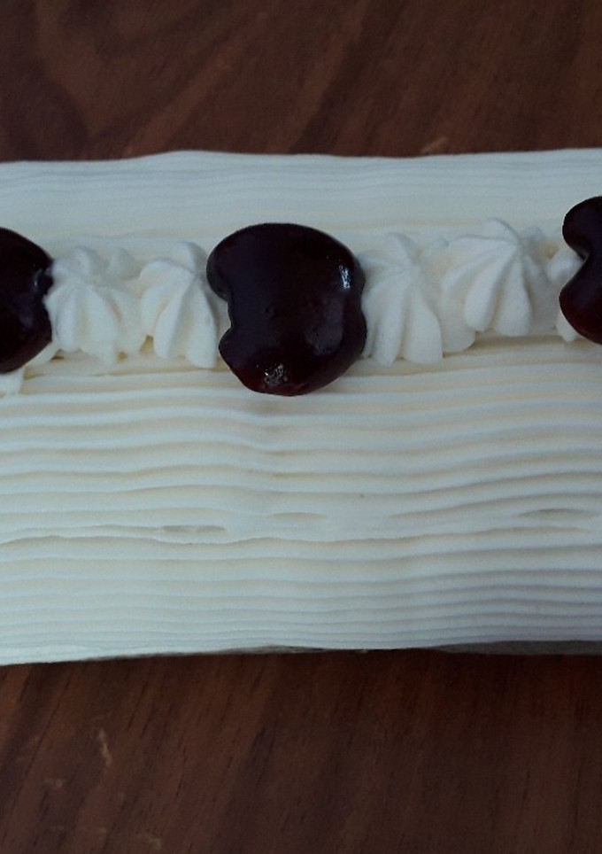 Una foto de Pionono relleno de dulce de leche, decorado con crema chantilly