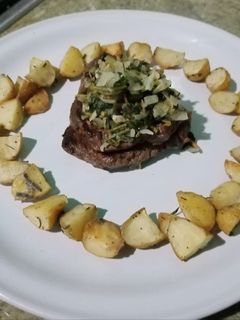 Una foto de Filete de res al perejil con papas rústicas