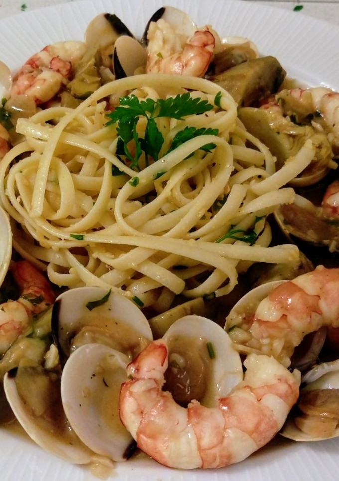 Una foto de Linguines de limón salteados con frutos secos y marisco al ajillo con alcachofas