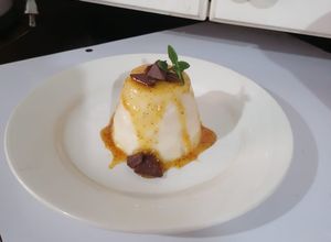 Una foto de Panna cotta de coco con coulis de maracuyá con mezcal