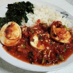 A picture of Egg curry served with rice and spinach.