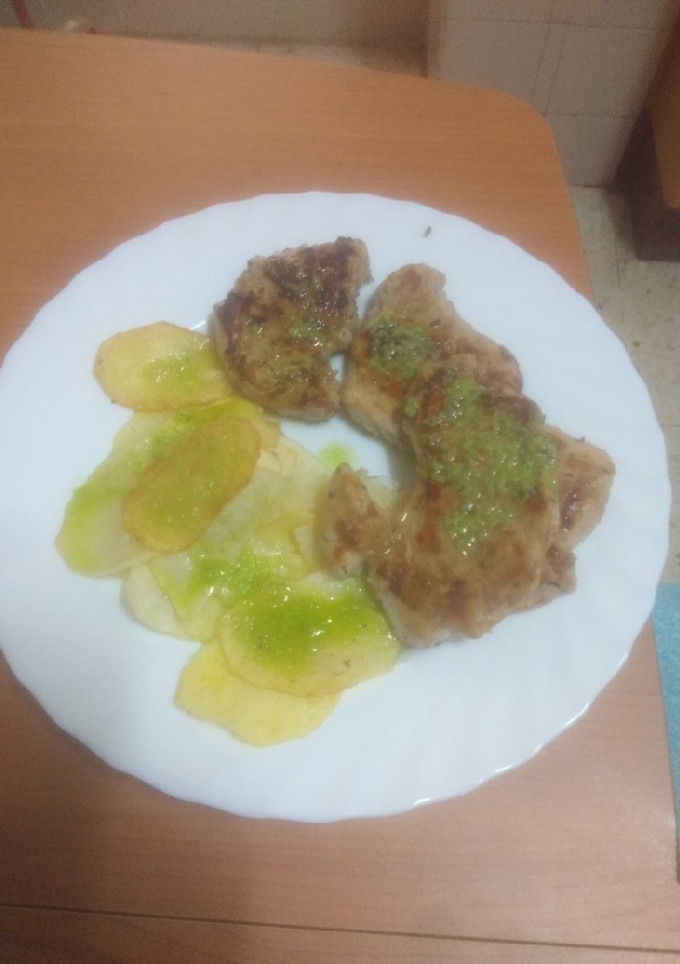 Una foto de Solomillo de cerdo a la plancha con papas chips y aceite de ajo