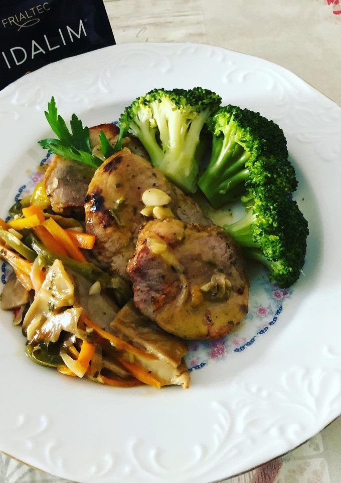 Una foto de Solomillo de cerdo adobado con brócoli y guarnición de setas salteadas y aderezo Vidalim