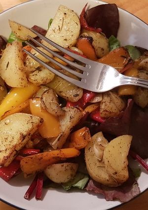 A picture of Baked potato wedges and peppers.