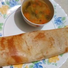 A picture of Dosa with moong dal veg curry.