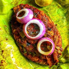 A picture of Meen Pollichathu- Kerala style fried fish steamed in banana leaf.