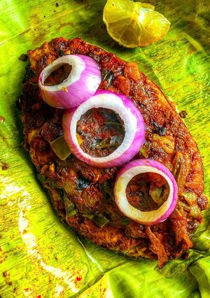 A picture of Meen Pollichathu- Kerala style fried fish steamed in banana leaf.