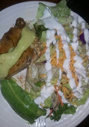 A picture of lemon chicken w salad cucumber dressing.