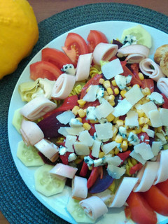 Una foto de Ensalada mixta de pasta, verduras y queso de cabra empanado